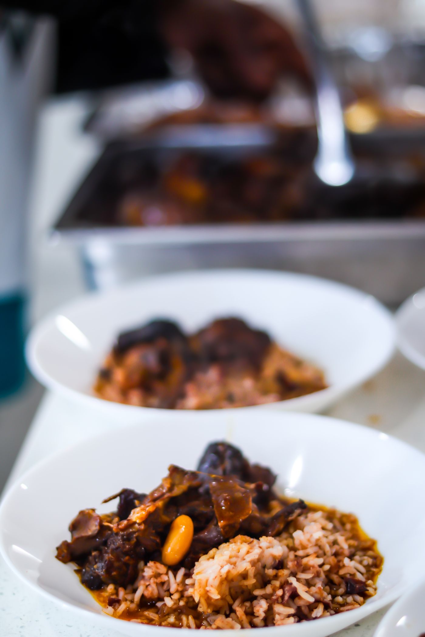 Braised oxtail in glossy gravy over rice and peas